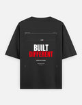 Built Different oversized black t-shirt by Oversteer Studios featuring a bold performance-inspired graphic with a minimalist technical design.